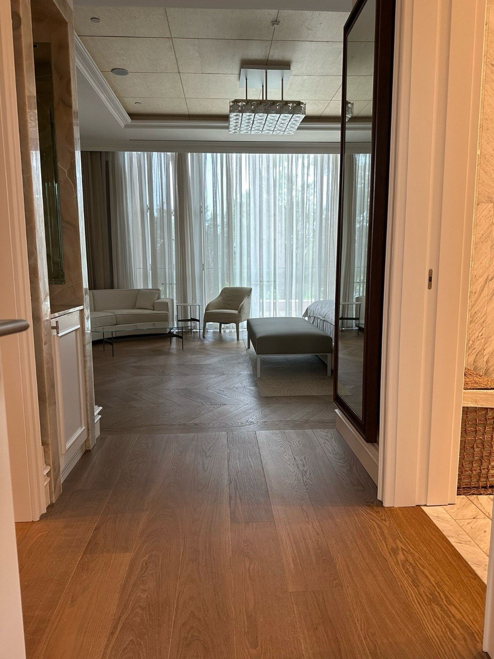 Wide oak plank floor leading into a bedroom laid in chevron