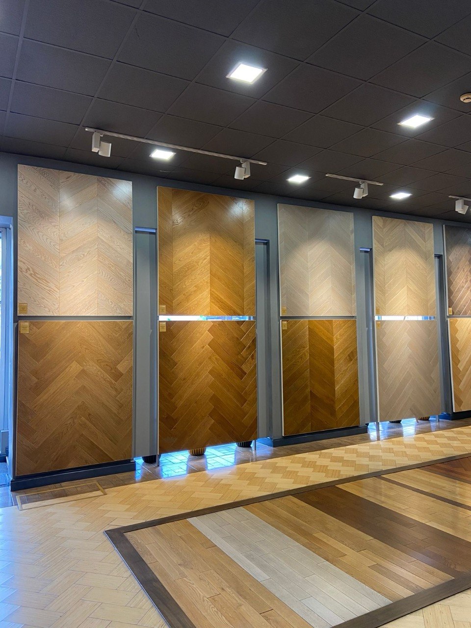 Showroom wall of oak chevron and herringbone parquet panels